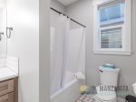 The second bathroom with stand-in shower tub with shampoos provided.
